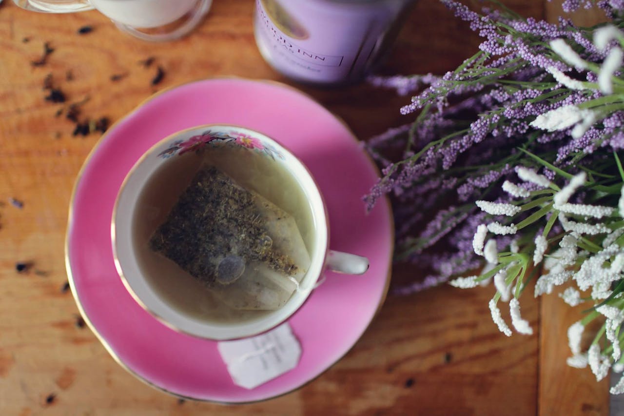 Enjoy a calming herbal tea with lavender and aromatic herbs in a pink floral teacup.